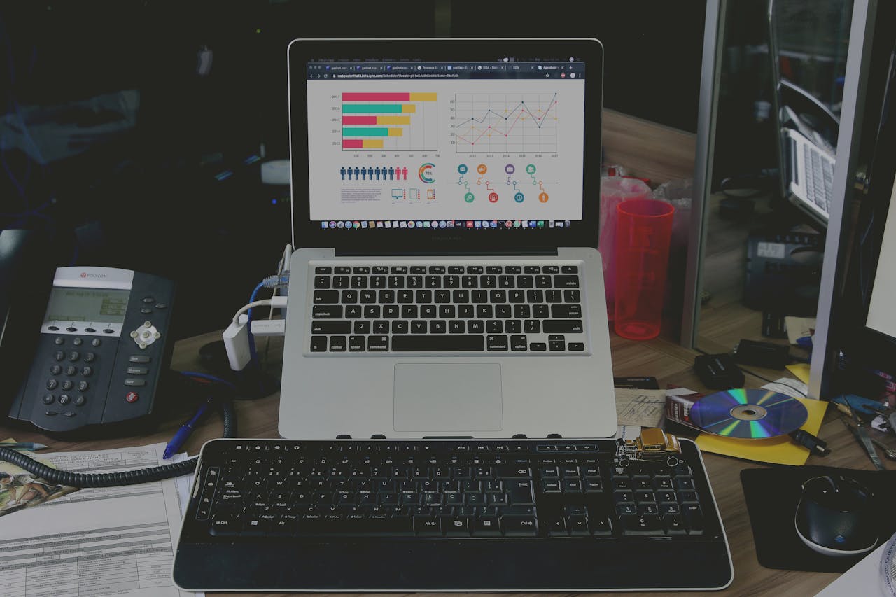 A tidy workspace featuring a laptop displaying colorful data graphs, illustrating a tech-savvy environment.